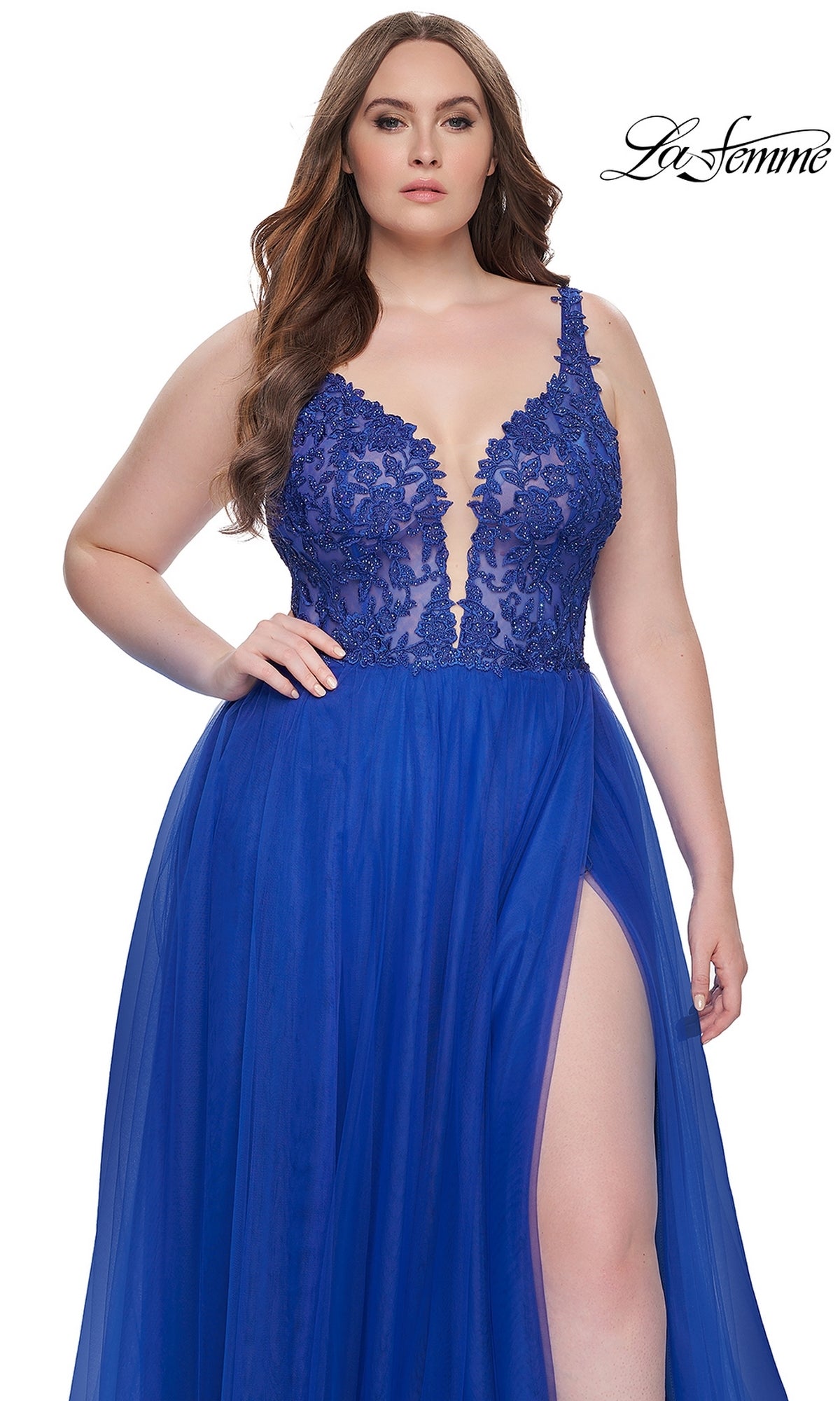 A woman wearing the La Femme Long Prom Dress 31394, a royal blue gown with a deep V-neckline, embroidered lace bodice, and high slit, stands against a plain white background.